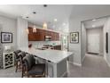Open-concept kitchen with island seating, pendant lighting, stainless steel appliances, and a view of the foyer at 2597 E Hickory St, Gilbert, AZ 85298