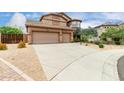 Gorgeous home with a three-car garage and desert landscaping surrounding a long driveway at 26956 N 83Rd Gln, Peoria, AZ 85383