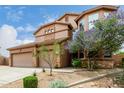 Attractive home showcasing a three-car garage and inviting desert landscaping at 26956 N 83Rd Gln, Peoria, AZ 85383