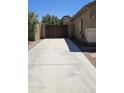 Long driveway leading to a stained, wood double gate for easy access to the backyard at 28093 N Pasture Canyon Dr, San Tan Valley, AZ 85143