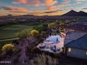 Aerial shot of the backyard pool, patio, and desert landscaping, adjacent to a golf course at sunset at 31108 N 122Nd Ln, Peoria, AZ 85383