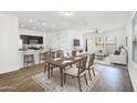 Open-concept living and dining area with hardwood floors and a view into the modern kitchen at 33731 N Bowles Dr, San Tan Valley, AZ 85144