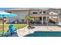 Outdoor living area with a covered patio, grill, and seating next to a pool and lush green lawn at 3580 W Dublin St, Chandler, AZ 85226
