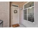Charming front door with wreath and 'hello' doormat, complemented by a secure window with bars at 3830 E Lakewood E Pkwy # 2126, Phoenix, AZ 85048