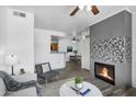 Bright open-concept living area featuring a modern fireplace and seamless transition to the dining area at 3830 E Lakewood E Pkwy # 2126, Phoenix, AZ 85048