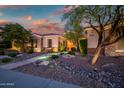 Charming single-story home with stone accents, desert landscaping, and well-lit walkway for curb appeal at 40123 N Majesty Trl, Anthem, AZ 85086