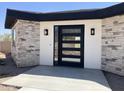 Close up of front door with black trim and stone accents at 4079 E Roosevelt St, Apache Junction, AZ 85119