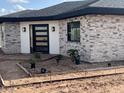 Newly constructed home with stone accents and a modern, dark-trimmed glass front door at 4079 E Roosevelt St, Apache Junction, AZ 85119