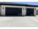 Spacious two car garage with modern black garage doors and concrete driveway at 4079 E Roosevelt St, Apache Junction, AZ 85119