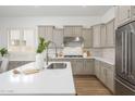 Contemporary kitchen with white countertops, stainless steel appliances, and stylish neutral-colored cabinets at 4266 E Blue Sage Ct, Gilbert, AZ 85297