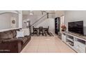 Open concept living room with tile flooring, a staircase, and comfortable seating at 45539 W Long Way, Maricopa, AZ 85139