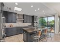 Modern kitchen boasts granite counters, stainless appliances, custom cabinets, and a breakfast bar with seating at 7222 E Gainey Ranch Rd # 245, Scottsdale, AZ 85258