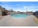 Backyard swimming pool with surrounding concrete patio and block fence for privacy at 724 N Pine St, Gilbert, AZ 85233