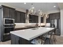 Gourmet kitchen with quartz counters, stainless appliances, and elegant pendant lighting at 8040 E Jaeger St, Mesa, AZ 85207
