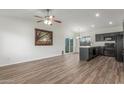 Open-concept living room with modern flooring, a ceiling fan, and a combined view of the kitchen at 1047 W Laguna Dr, Tempe, AZ 85282