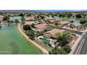 Aerial view of a lakeside home showcasing a private pool, lush landscaping, and community lake access at 11101 W Wilshire Dr, Avondale, AZ 85392