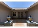 Inviting front porch featuring decorative lanterns, a secure gated entry, and a charming view of the home's facade at 12719 W Ashwood Dr, Sun City West, AZ 85375