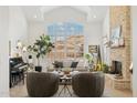 Stunning living room with vaulted ceilings, a stone fireplace, and large windows offering plenty of natural light at 1285 E Horseshoe Ave, Gilbert, AZ 85296