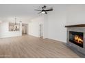 Open-concept living room with a fireplace, neutral decor, and hardwood floors at 14239 N Edgeworth Dr # A, Fountain Hills, AZ 85268