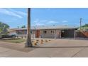 Lovely exterior featuring desert landscaping, an orange entry door, and a covered carport at 1617 W Lamar Rd, Phoenix, AZ 85015