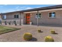 Inviting exterior featuring desert landscaping, brickwork, and a brightly painted orange entry door at 1617 W Lamar Rd, Phoenix, AZ 85015