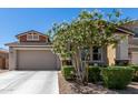 Charming single-Gathering home boasts desert landscaping, a two-car garage, and a covered porch with stone accents at 17171 W Tonto St, Goodyear, AZ 85338