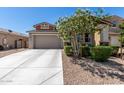 Charming single-Gathering home boasts desert landscaping, a two-car garage, and a covered porch with stone accents at 17171 W Tonto St, Goodyear, AZ 85338