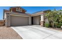 Charming single-Gathering home boasts desert landscaping, a two-car garage, and a covered porch with stone accents at 17171 W Tonto St, Goodyear, AZ 85338