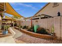 Stone pathway in a landscaped backyard leading to a covered outdoor kitchen area at 18501 E Pine Valley Dr, Queen Creek, AZ 85142