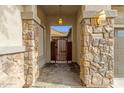 Inviting entryway with stone pillars and gated access to the home's front door and stylish house number at 18501 E Pine Valley Dr, Queen Creek, AZ 85142