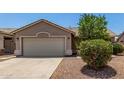 Front view of charming home showcasing low maintenance landscaping, stucco exterior and two car garage at 2191 W Goldmine Mountain Dr, Queen Creek, AZ 85144