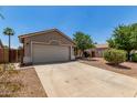 Single level home with desert landscaping, two car garage and a concrete driveway at 2191 W Goldmine Mountain Dr, Queen Creek, AZ 85144