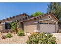 View of the home's front exterior with desert landscaping and a two-car garage at 22056 N 32Nd Ave, Phoenix, AZ 85027
