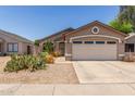 Front view of a single-story house with a two-car garage and desert landscaping at 22056 N 32Nd Ave, Phoenix, AZ 85027