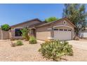 Single-level house featuring desert landscaping, neutral tones, and a two-car garage at 22056 N 32Nd Ave, Phoenix, AZ 85027