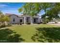 Attractive front exterior of a home with a well-maintained lawn and mature trees at 24434 S 201St Ct, Queen Creek, AZ 85142