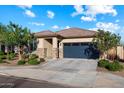 Lovely single-story home boasts a neutral color palette, stone accents, and a two-car gray garage door at 25119 N 134Th Dr, Peoria, AZ 85383