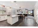 Open-concept kitchen flows into the dining and living area, featuring a central island with granite countertop at 25119 N 134Th Dr, Peoria, AZ 85383