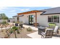 Inviting outdoor patio area with modern seating, desert landscaping, and stylish pergola at 26626 N 70Th Pl, Scottsdale, AZ 85266
