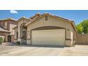 Home exterior features a beige stucco finish, with a two-car garage and an arched entryway at 2853 E Cathy Dr, Gilbert, AZ 85296