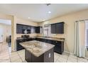 Modern kitchen with granite countertops, black cabinets, and an island at 2853 E Cathy Dr, Gilbert, AZ 85296