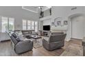 Spacious living room with a vaulted ceiling, a fireplace, and comfortable leather seating at 3139 E Runaway Bay Pl, Chandler, AZ 85249