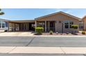 Charming single-story home with a covered porch and well-maintained landscaping at 3301 S Goldfield Rd # 6050, Apache Junction, AZ 85119