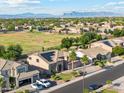 Scenic aerial view of a neighborhood with lush trees and blue mountains in the distance at 3574 E Latham Way, Gilbert, AZ 85297