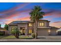 Stunning two-story home featuring a spacious three-car garage, lush landscaping, and a welcoming front entrance at sunset at 3574 E Latham Way, Gilbert, AZ 85297