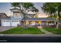 Charming two-story home with inviting front porch, stone accents, lush lawn, and a spacious driveway leading to the garage at 3824 N 50Th Pl, Phoenix, AZ 85018
