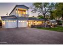 Inviting two-story home with stone accents, a well-lit porch, a spacious driveway, and lush green lawn for curb appeal at 3824 N 50Th Pl, Phoenix, AZ 85018
