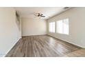 Bright living room featuring attractive wood-look flooring and large windows at 409 E Saddle Way, San Tan Valley, AZ 85143