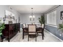 Formal dining room with modern lighting, plush rug, and stylish decor elements at 4441 W Windrose Dr, Glendale, AZ 85304