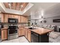 Spacious open kitchen with stainless steel appliances and an island, flowing into the living room at 4441 W Windrose Dr, Glendale, AZ 85304